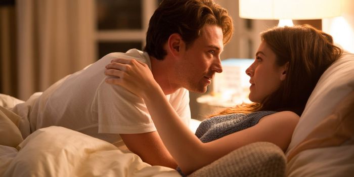 A couple engaging in a deep, stress-reducing conversation before sleep.