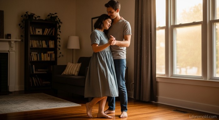 Happy couple dancing together barefoot in living room