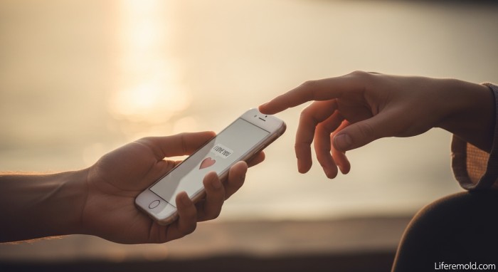 Hands touching while holding phone showing balance of digital and physical intimacy