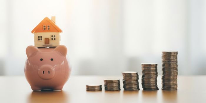 Piggy bank and house model representing down payment savings