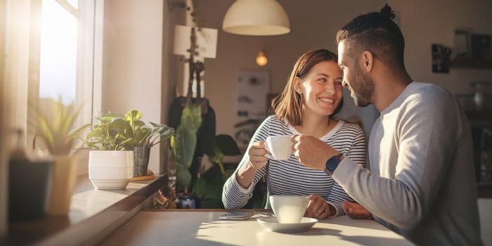 A happy couple connecting over coffee in the morning without phones, demonstrating a healthy relationship habit.