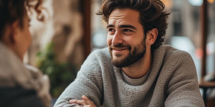 A man listening intently and with empathy to his partner in a cafe.