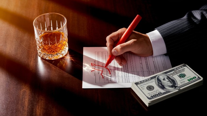 Man using red marker to cut expenses and follow reverse budget strategy