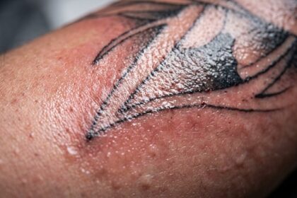 Close-up of fresh tattoo showing skin inflammation and ink settling during healing process day 1